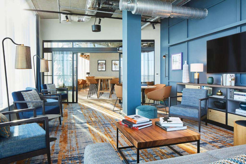 斯劳Residence Inn by Marriott Slough的客厅配有蓝色的椅子和桌子