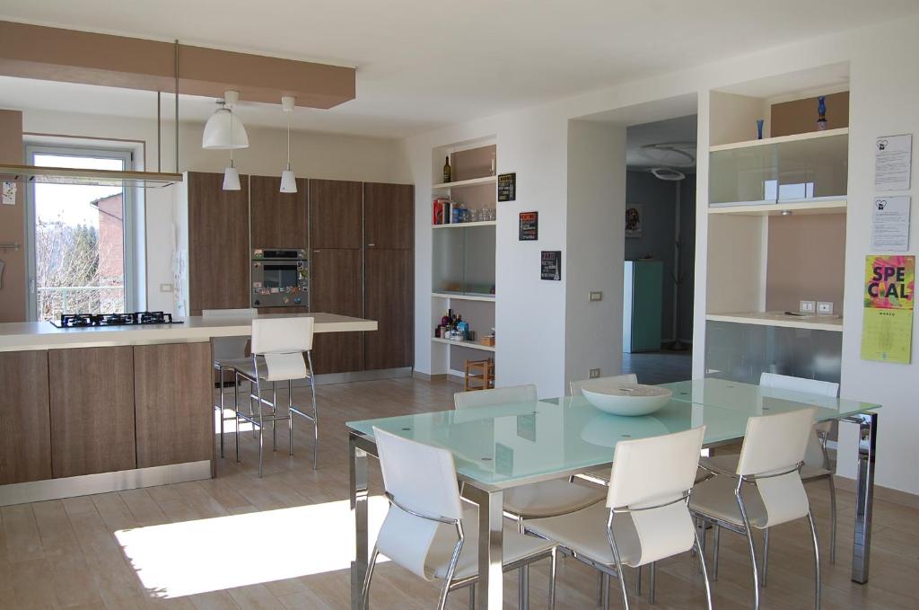 CastellʼAlferoMonferrato Asti-luminosa villa的厨房配有玻璃桌和白色椅子