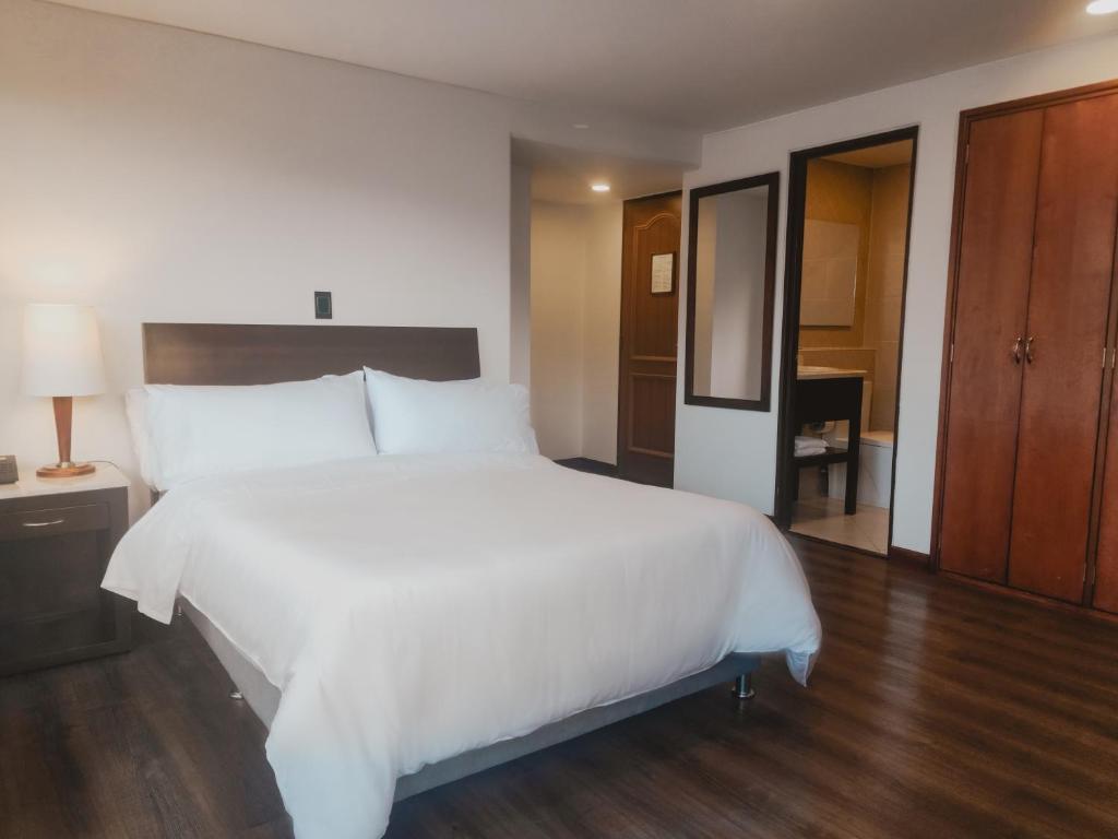 波哥大Faranda Express Belvedere的一张大白色的床,位于酒店客房内