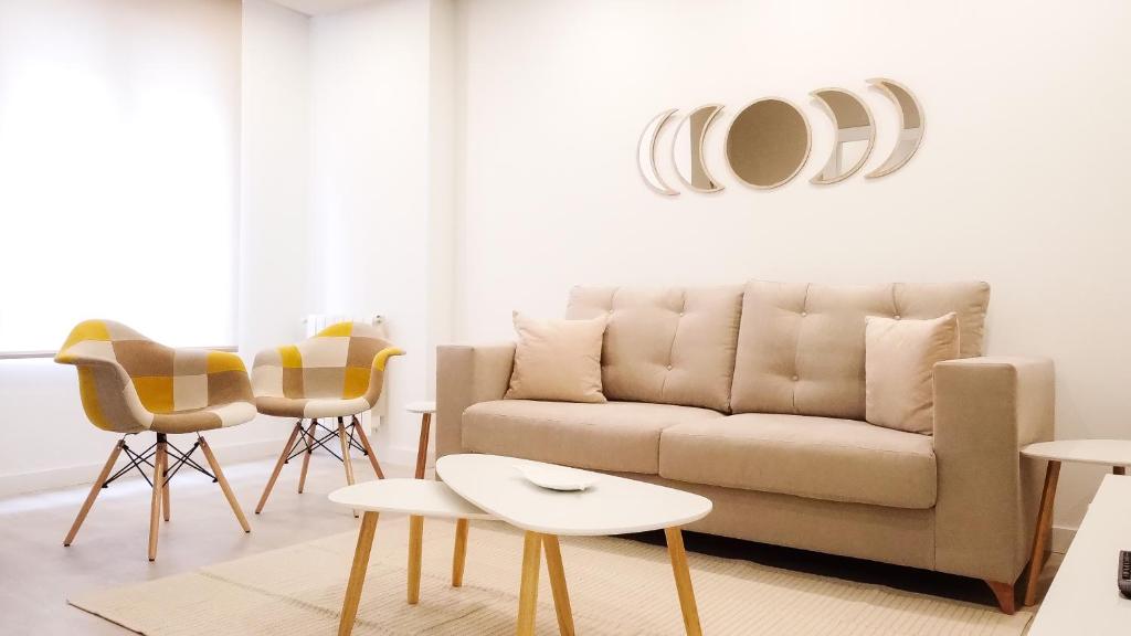 巴利亚多利德Apartamento DENVER - Centro, Nuevo, Diseño, Wifi的客厅配有沙发和椅子