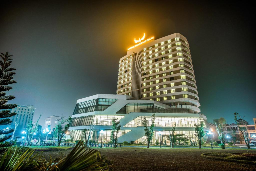 Bắc Giang北江孟青大酒店的一座高大的建筑,上面有光