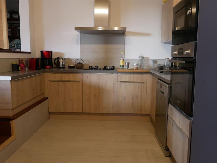 豪特尔La Villa créole的厨房配有木制橱柜和炉灶烤箱。