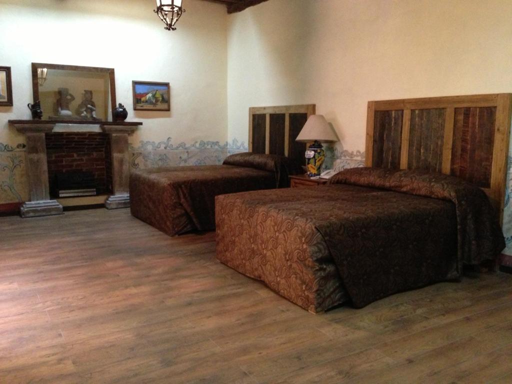 普埃布拉Hotel Travel的一间卧室设有两张床和一个壁炉