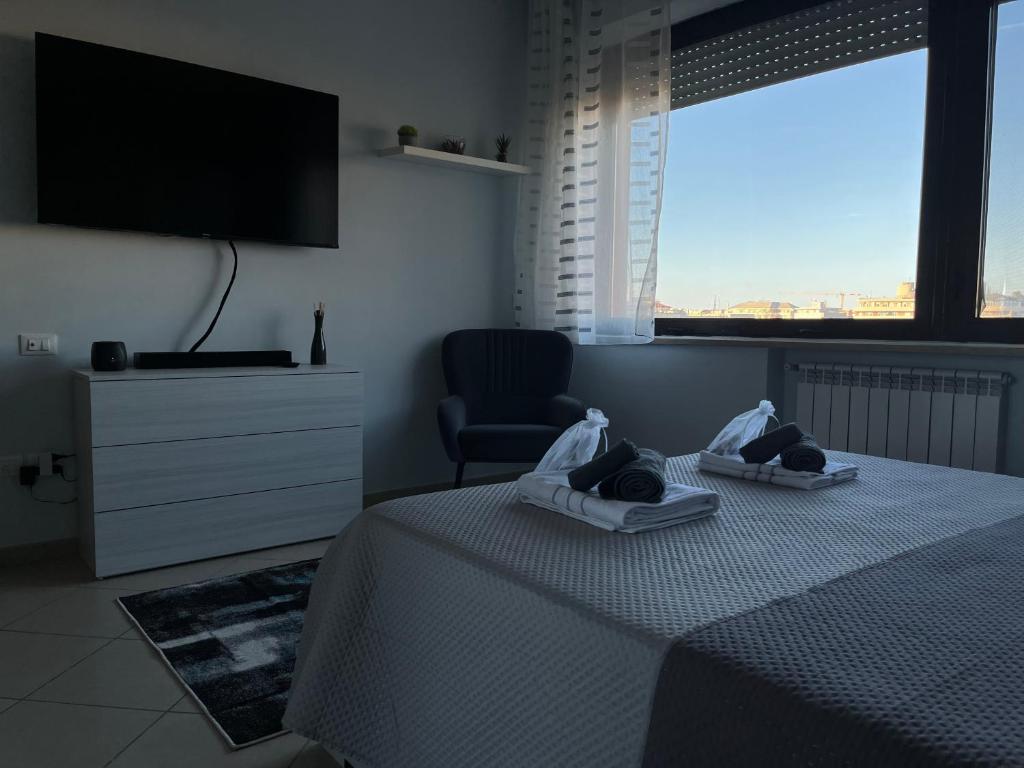 佩斯卡拉Casa Manthone - Intero Appartamento的一间卧室配有一张床、一把椅子和电视