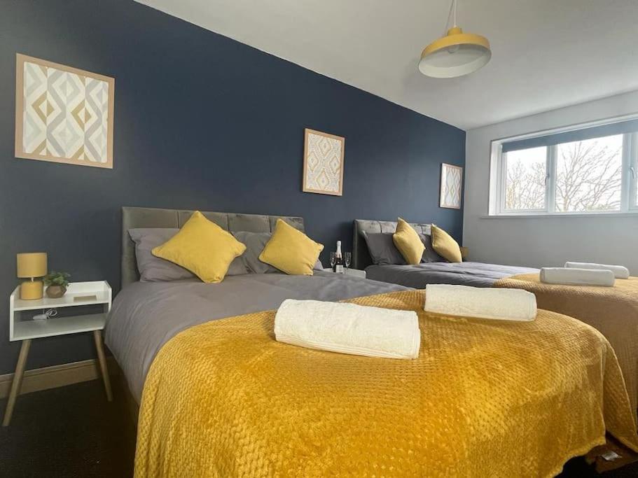 伯明翰Stylish 2 bed apartment.的一间卧室配有两张带黄床单的床