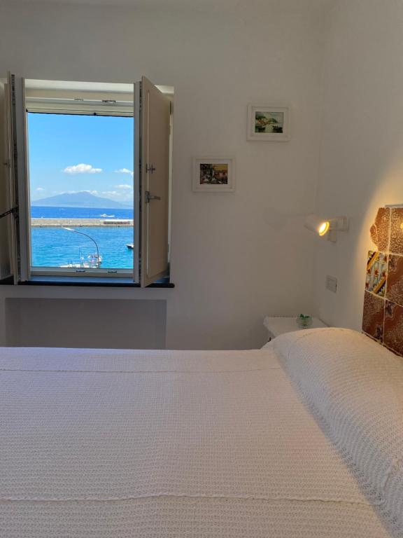 卡普里La Baia di Napoli的一间卧室设有一张大床和一个窗户。