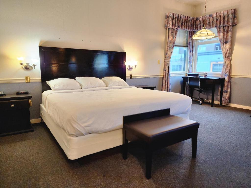里士满The Steveston Cafe & Hotel的卧室配有一张白色大床和一张书桌