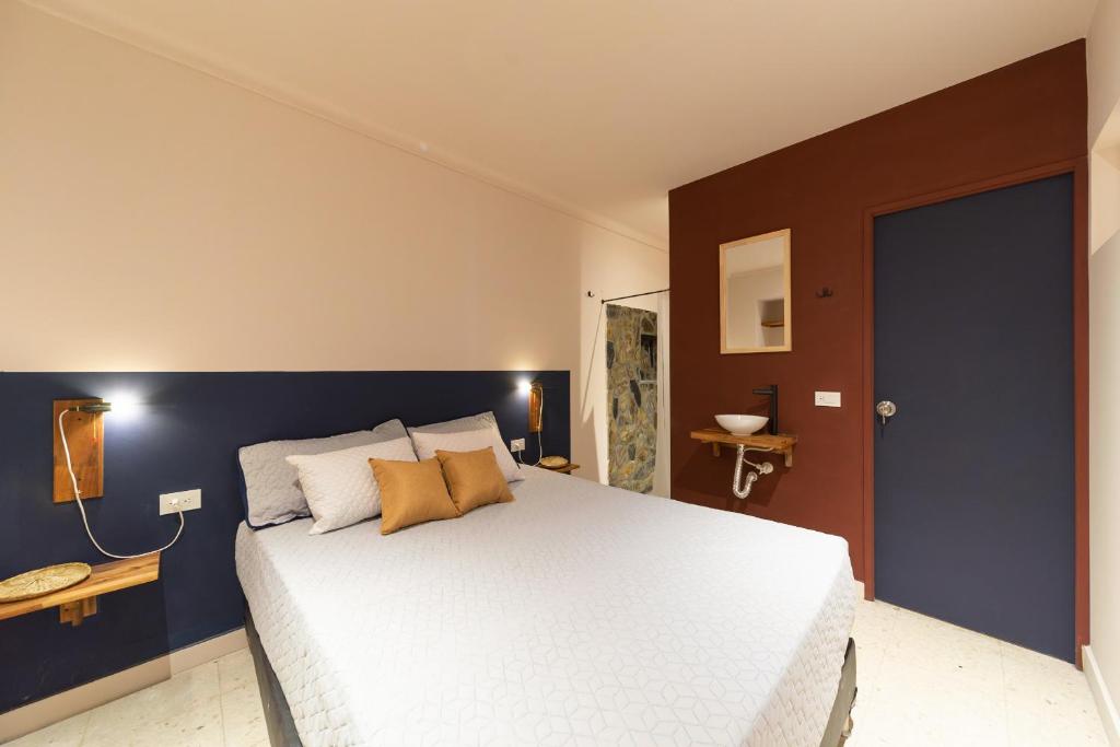 麦德林Hostal Casa Mosaiko Nutibara Laureles的一间卧室配有一张白色大床和蓝色的墙壁