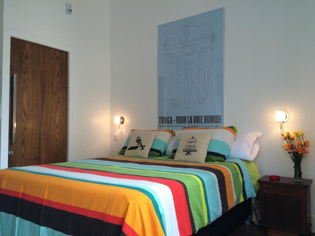 里约热内卢Studio Rio Beira Mar的一间卧室配有一张带彩色毯子的床