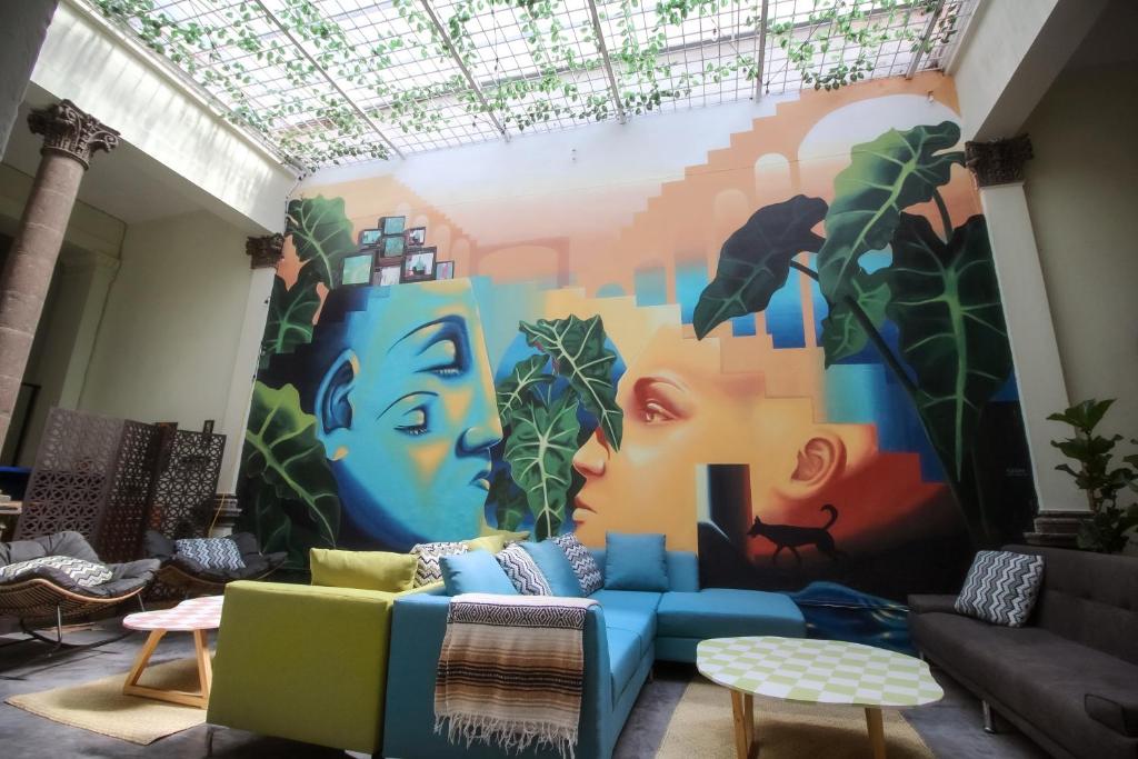 瓜达拉哈拉Art House Hostel Guadalajara的客厅墙上挂着壁画