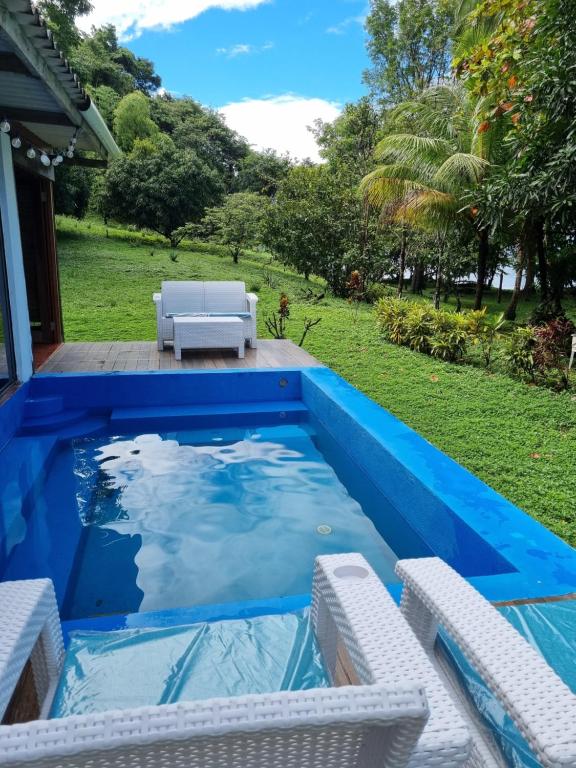 Isla Cebaco Isla Cébaco的一个带白色椅子的游泳池和一个蓝色的游泳池