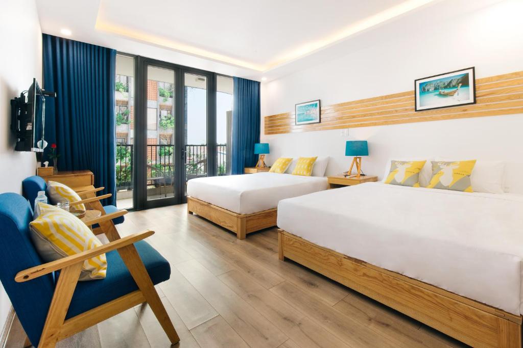 岘港La Maison De Fleurs的酒店客房,配有两张床和椅子