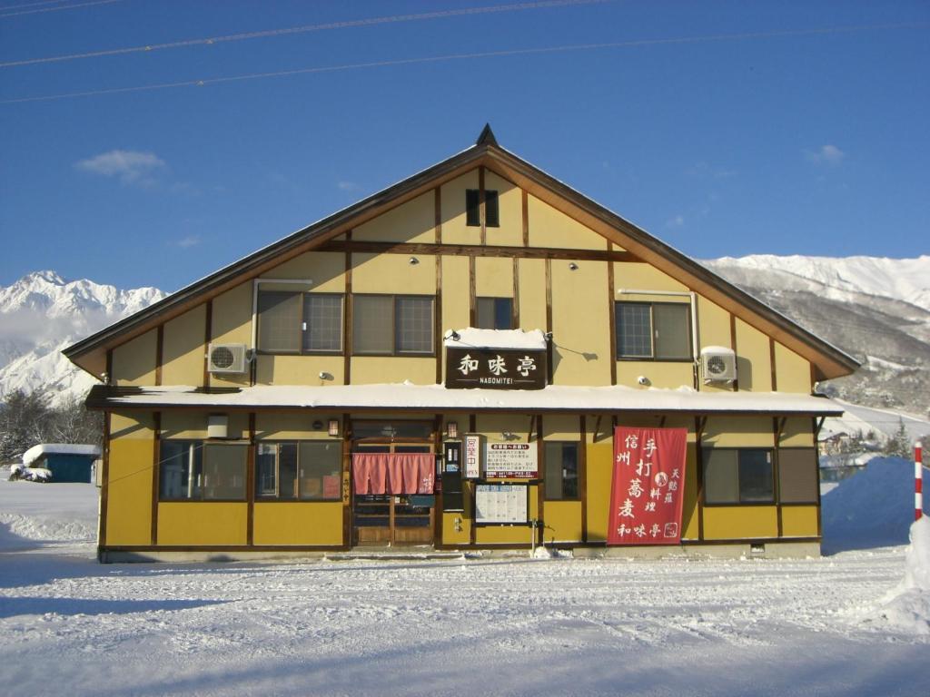 白马村和味亭日式旅馆的雪上标有标志的建筑
