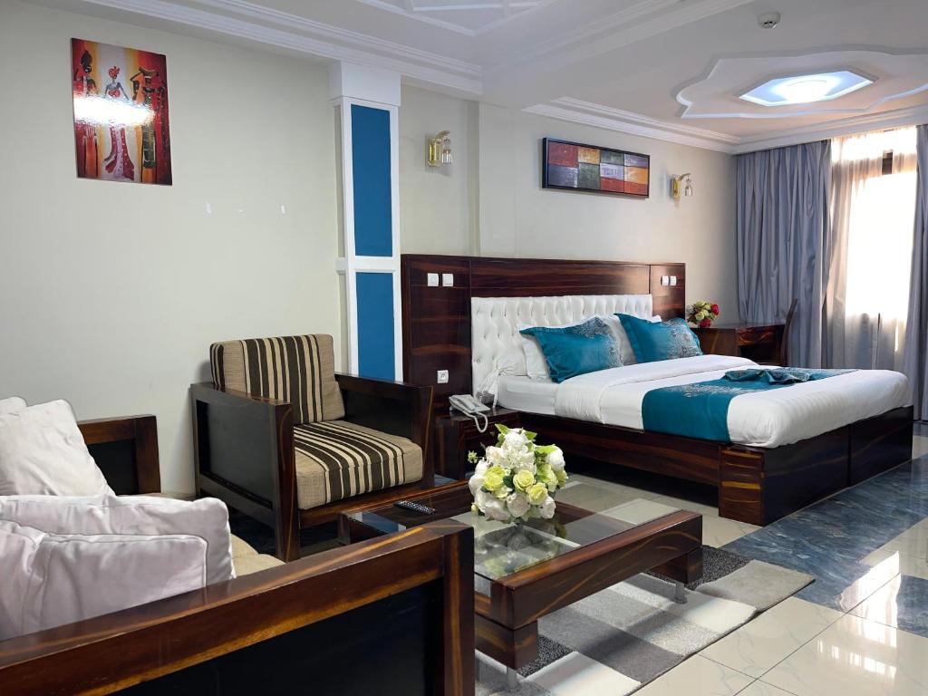 雅温得Hotel Le Kremlin Yaoundé的一间卧室设有一张床和一间客厅。
