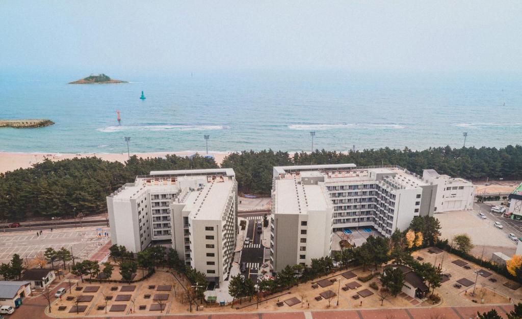 束草市Risen Ocean Park Hotel的享有海滩的空中景致,拥有白色的建筑