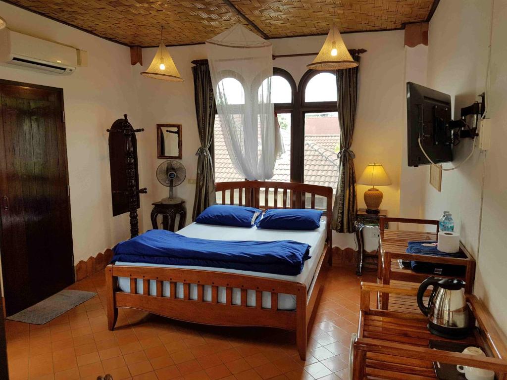 廊开玛米花园旅馆的一间卧室设有一张床、一台电视和一个窗口。