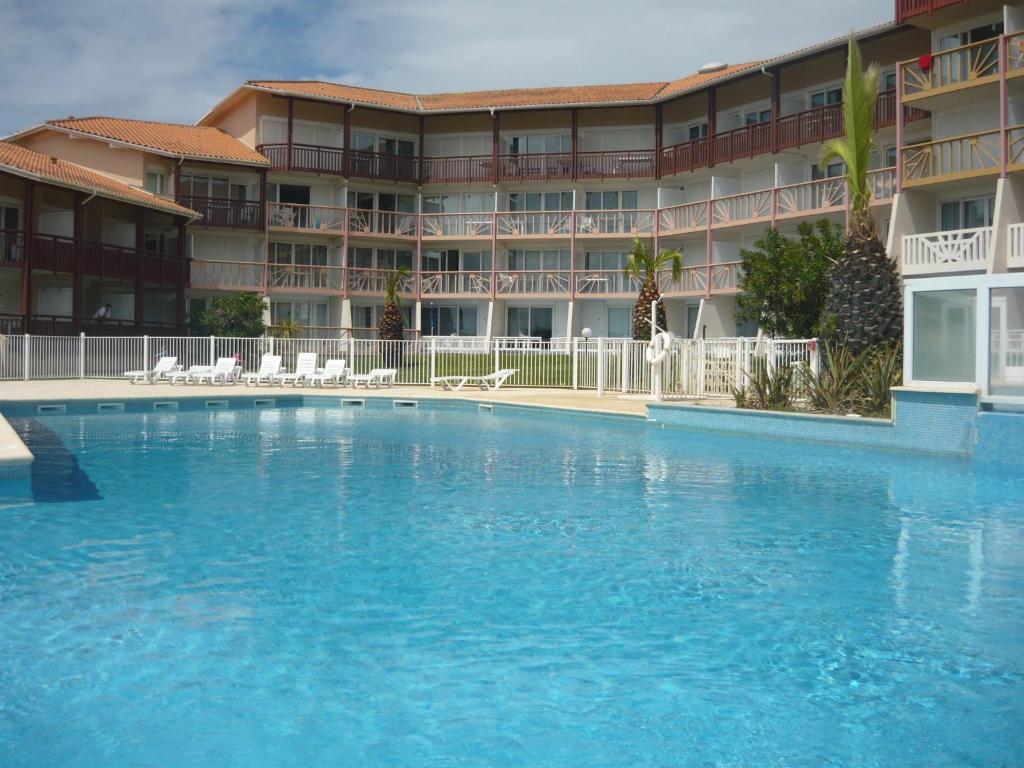 布科·莱斯白老城Appartements à côté Lac Marin de Port d'Albret的酒店前方的大型游泳池