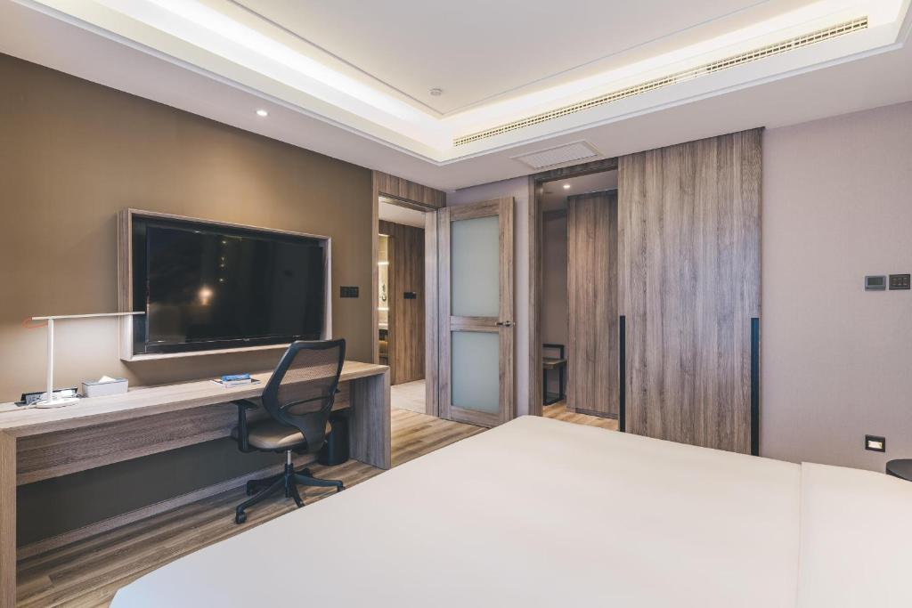 重庆重庆江北机场亚朵酒店的客房设有一张床、一张书桌和电视