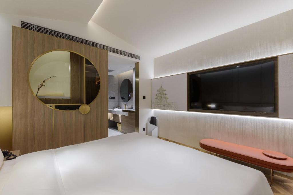 北京北京中关村北外亚朵S酒店的卧室配有一张白色大床和电视。