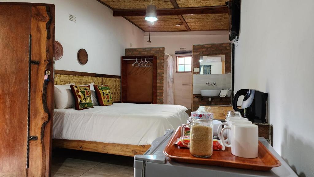 卡萨内Nxabii Cottages的一间卧室配有一张床,浴室设有水槽