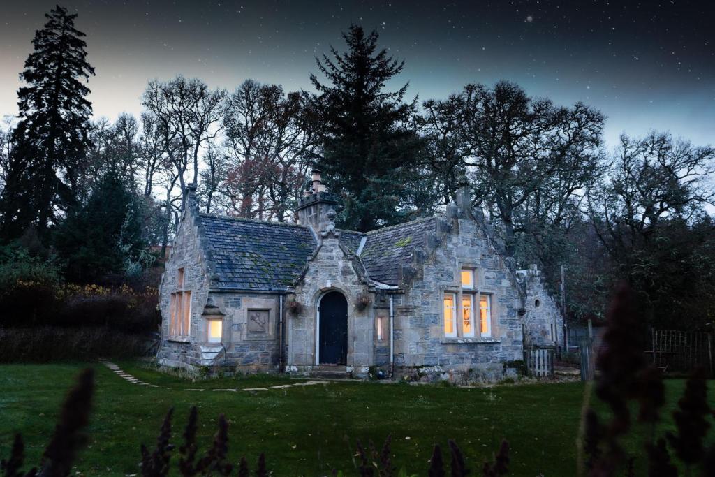 金克雷格West Lodge - Seasgair Lodges的夜晚在田野里的一座古老的石头房子