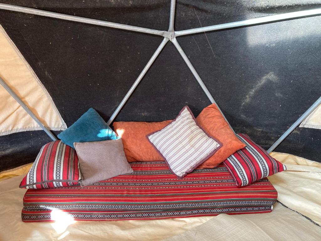 米茨佩·拉蒙Skyline eco-camp的一组枕头放在伞下的床上