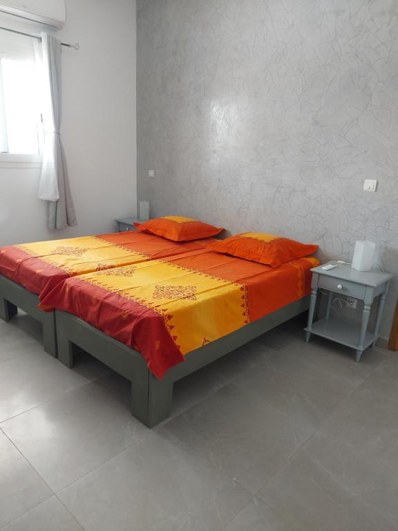 萨利波图尔Keur M et M的一张橙色和黄色床单的床