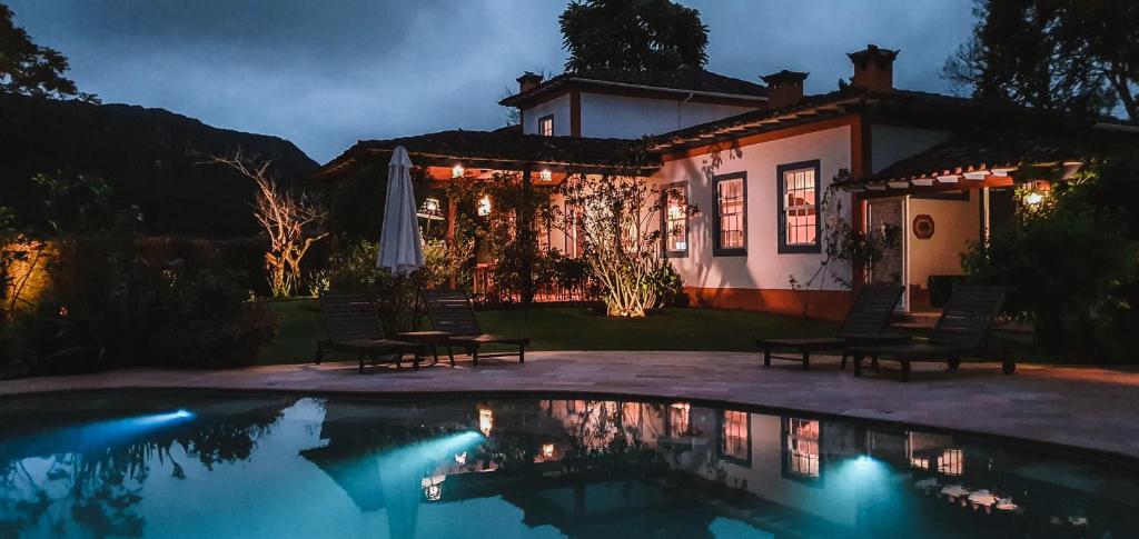 蒂拉登特斯Amana Tiradentes的房屋前有游泳池的房子