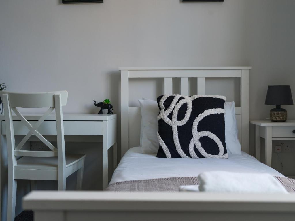BedlingtonLilys Apartment 2- 2bedroom, Northumberland的白色的床、白色的书桌和枕头