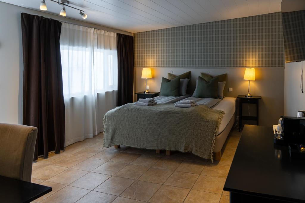 VegamótHOTEL SNAEFELLSNES formally Hotel Rjukandi的一间卧室配有一张带绿色枕头的大床