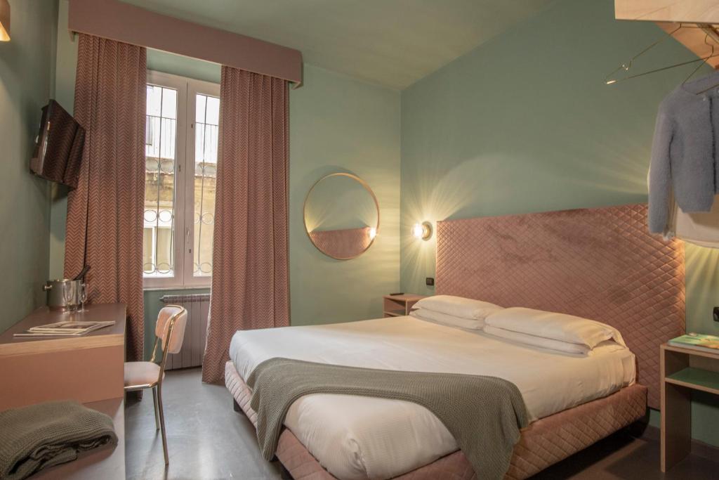 罗马米拉尼酒店的一间卧室配有一张大床和镜子