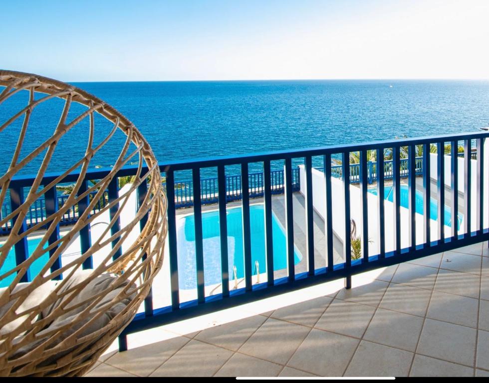卡列罗港FRONTLINE VILLA 25, Modern Coastal Design with Amazing Views的俯瞰大海的阳台上的藤椅