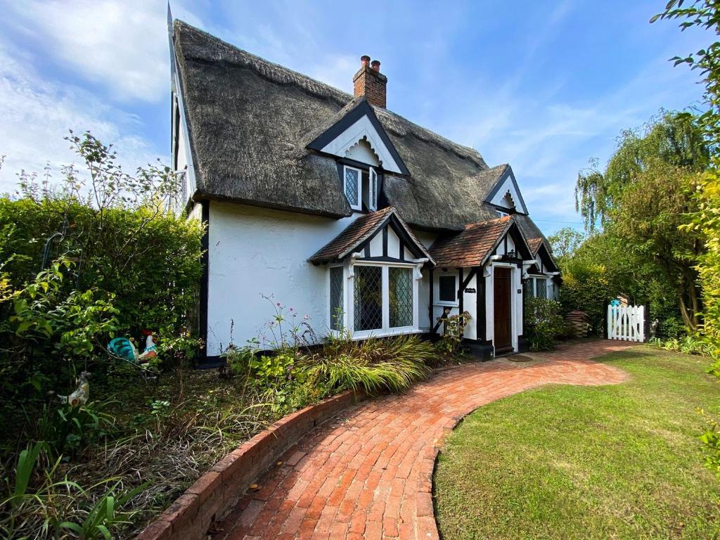 斯托马基特Laburnham Cottage的白色的小小屋,设有茅草屋顶