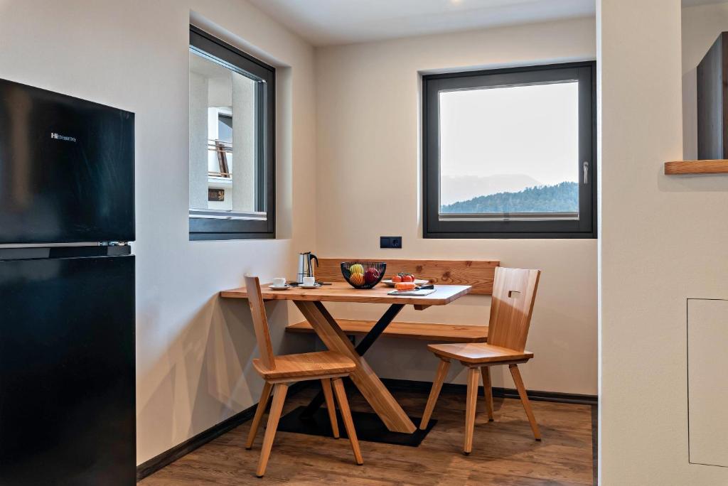 卡斯特尔罗托Villa Lara Lärche的一个带桌椅和窗户的小厨房