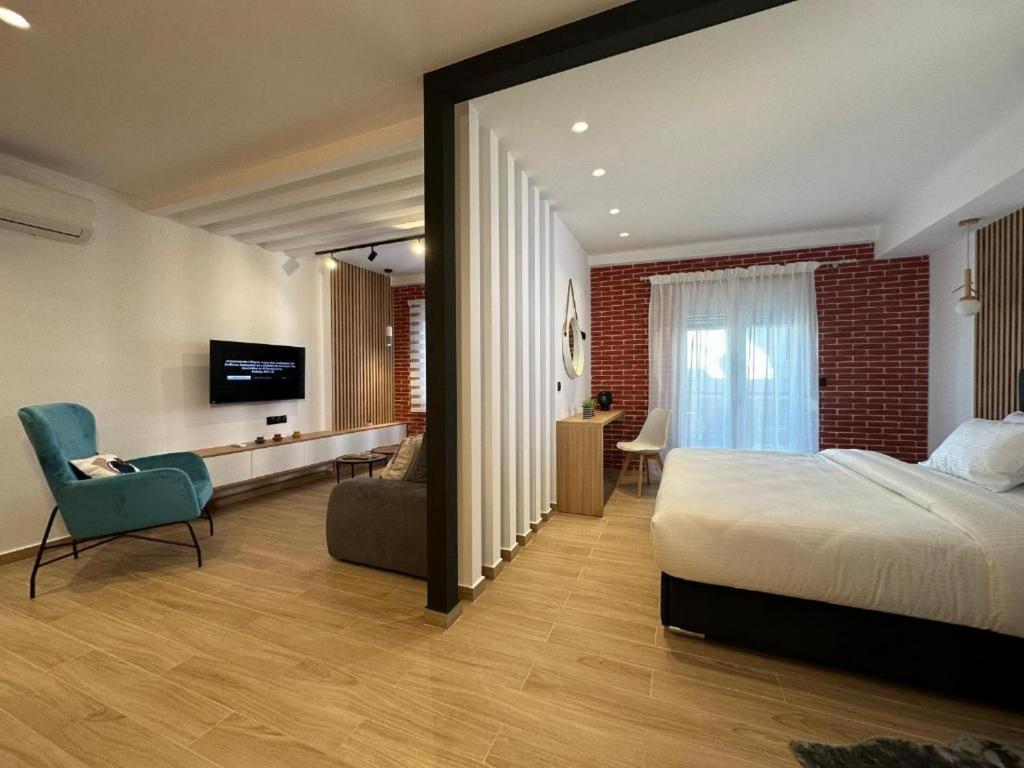 卡兰巴卡Centro Urban Suites的一间卧室配有一张床、一把椅子和电视