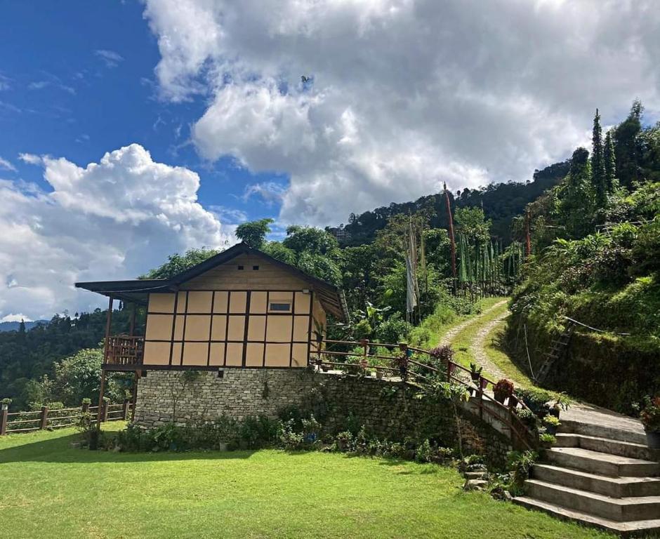 佩林Phamlhakhang Ecohomestay的一座小建筑,位于山上,设有楼梯和小径