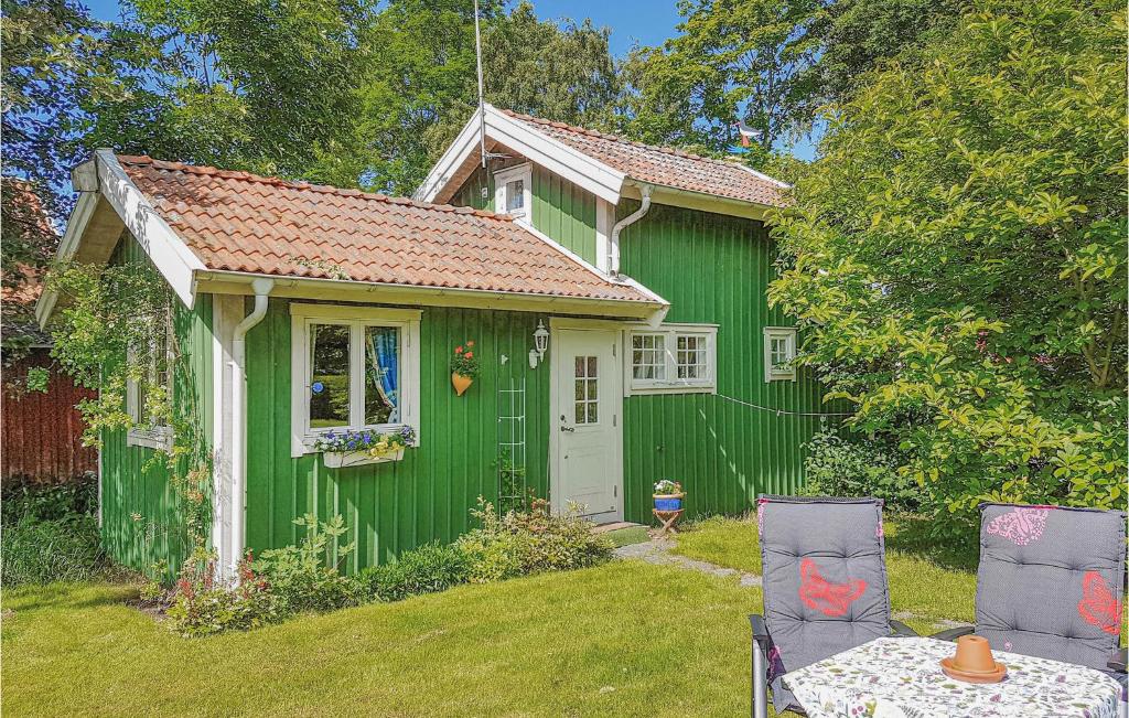 Onsala奥兰加一室公寓度假屋的前面设有桌椅的绿色房子