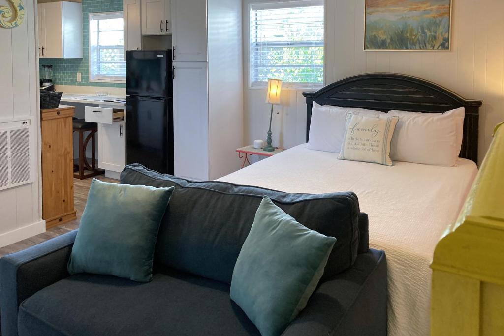 巴拿马城海滩Sunnyside Studio的一间卧室配有一张床和一张沙发,还设有一间厨房