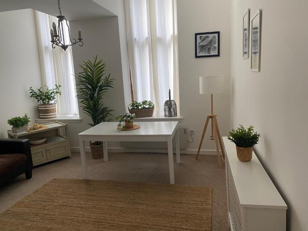 格拉斯哥Inviting 1-Bed Apartment in Merchant City的客厅配有白色桌子和盆栽植物