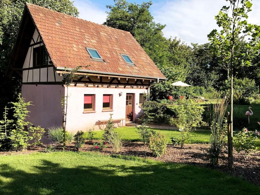 La Mouette Rose - a zen guest-house in Lauterbourg的一间白色的小房子,有红色的屋顶