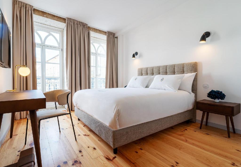 布拉加LP Heritage Apartments的卧室配有一张白色大床和一张书桌