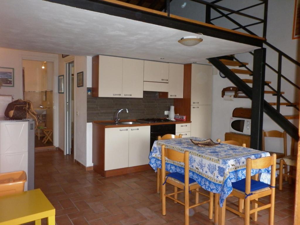 里奥马里纳Appartamenti Piombino Isola d'Elba的厨房以及带桌椅的用餐室。