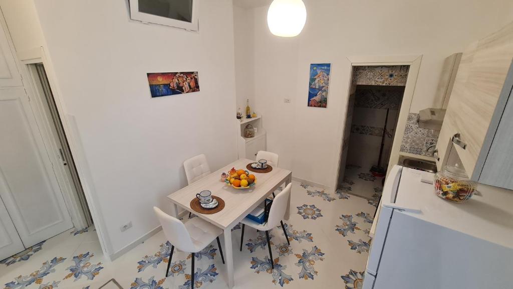 普莱伊亚诺Casa Piccina的厨房配有白色的桌椅和白色的冰箱。