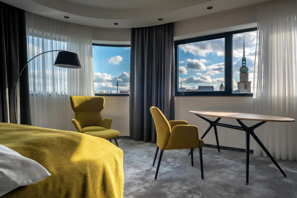 多特蒙德Hotel Esplanade Dortmund的酒店客房带一张床、一张桌子和椅子