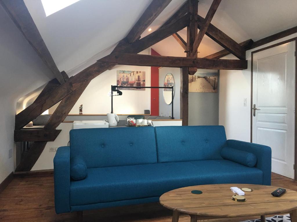 Saint-Pierre-de-FursacLa Mirabelle的客厅配有一张蓝色的沙发,配有一张桌子