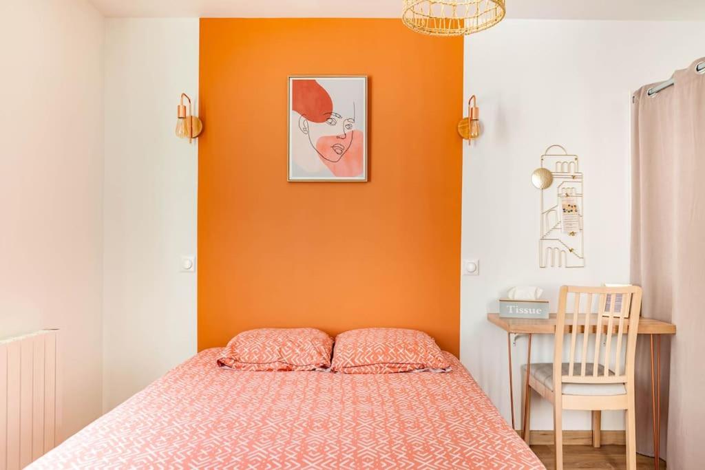 图尔Maison tourangelle chic & cosy avec cour的一间卧室设有橙色墙壁、一张床和一把椅子