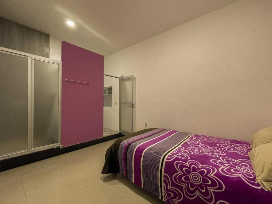 多洛雷斯-伊达尔戈La Casa de Colores.的一间卧室配有紫色的床和滑动玻璃门