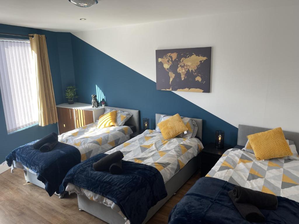 利物浦Anfield accomodation的一间卧室设有两张床和蓝色的墙壁