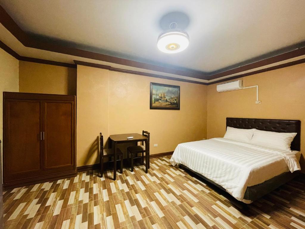 安吉利斯Drake Hotel Angeles City的一间卧室配有一张床和一张桌子