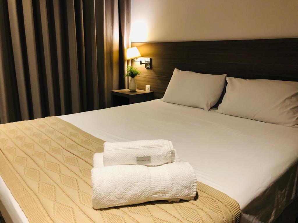 里约热内卢Apto tipo Flat Midas Riocentro - Barra da Tijuca- Barra olímpica的酒店客房,配有带毛巾的床